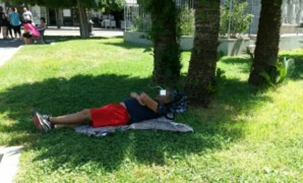 Pompei - Visitatori e turisti stesi sul prato all’ombra degli alberi di Piazza Bartolo Longo 