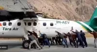 L'aereo buca una ruota e i passeggeri lo spingono lungo la pista. Il video